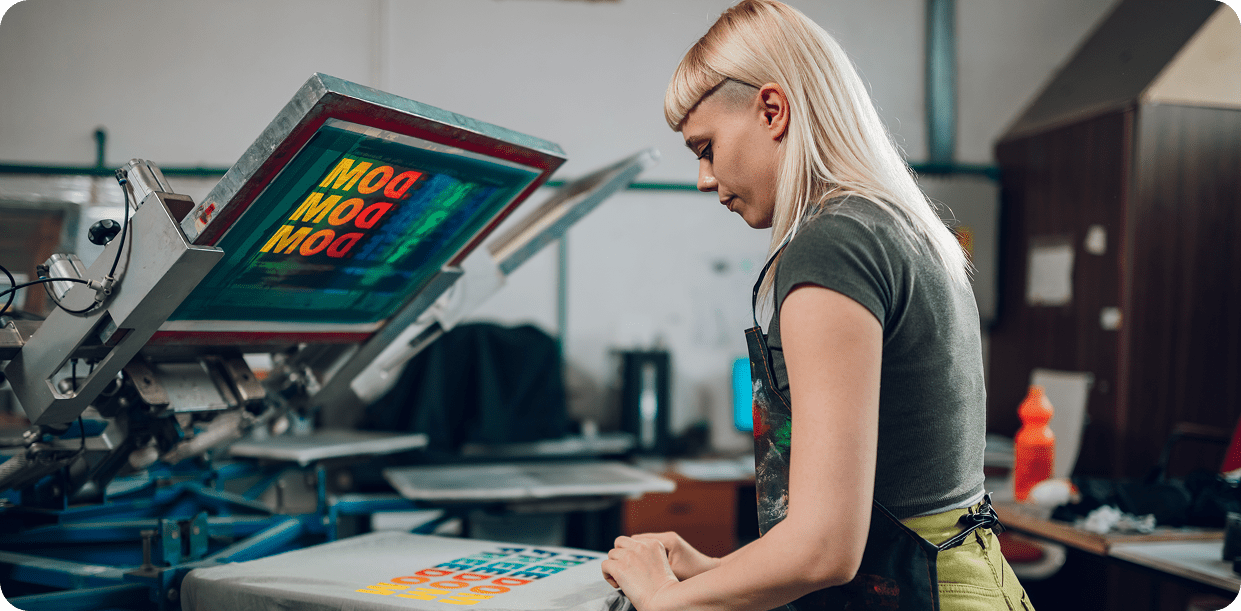 Woman working on screen printing machine
